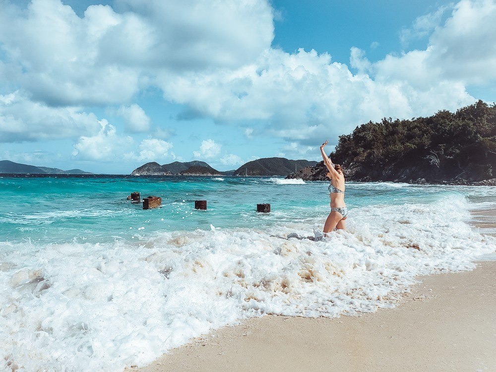 girl splashing in the waves at Denis Bay - St John underrated beaches