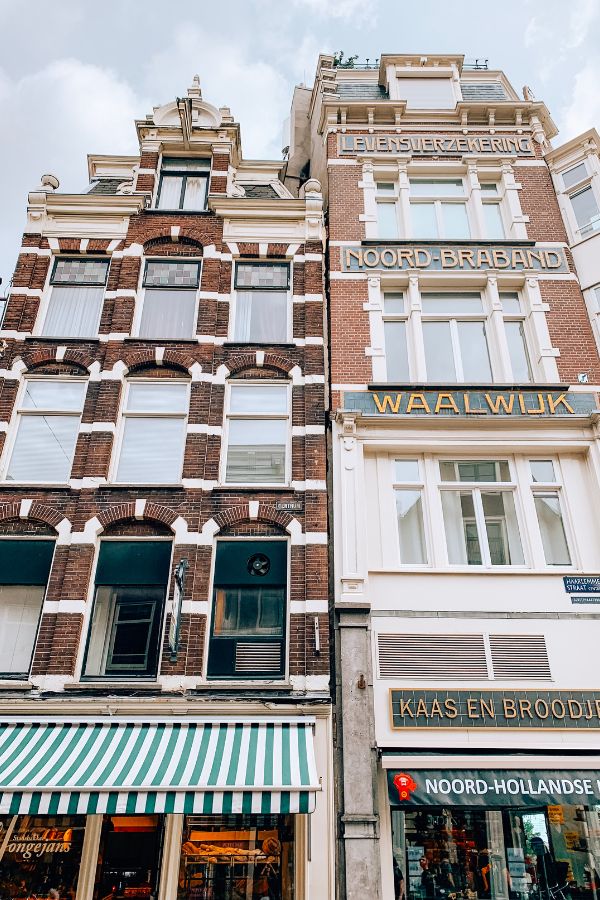 Two traditional Dutch brick buildings standing side by side in Amsterdam